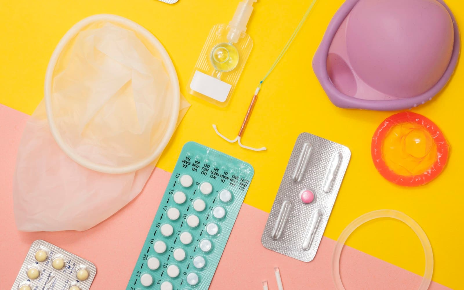 Condoms, contraception and sexual health supplies arranged on a colourful background